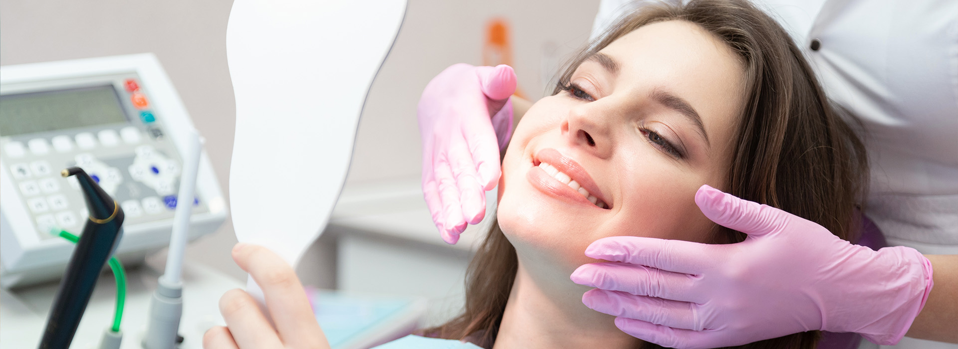 A woman receiving dental care with a dentist s hand holding her chin.