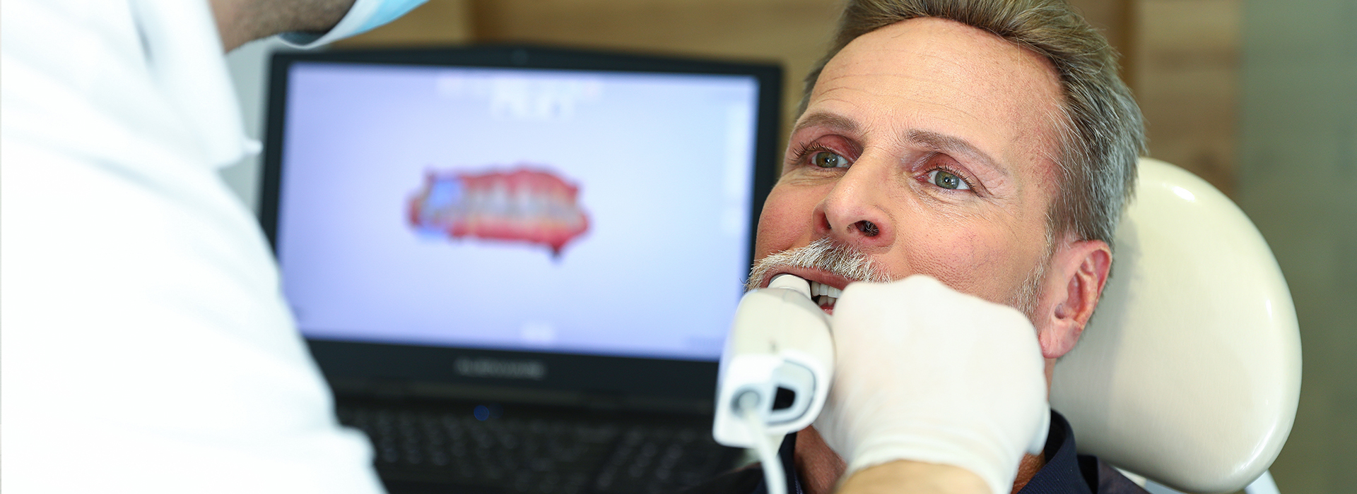 A man receiving dental treatment with a dentist performing the procedure.